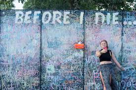 Girl in front of Before I Die wall